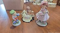 All three porcelain child figurines on table