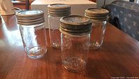 four sample jars showing embossed glass and metal lids