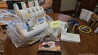 White Superlock 2000 ATS serger on table with accessories and Philips iron box visible