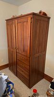 Full front view of wooden wardrobe showing two doors and four drawers
