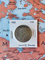 Obverse of 1980 Canadian dollar in labeled 2×2 holder