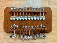 Full view of wooden rack holding 24 souvenir spoons