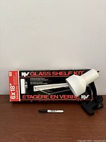 Lamp and boxed glass shelf kit on table