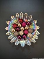 Top view of iridescent scalloped glass bowl filled with multi-coloured ornaments
