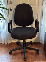Front view of black office chair showing seat, backrest, armrests and base