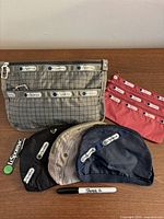 All five LeSportsac pouches with Sharpie for scale