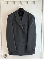 Full front view of dark gray suit jacket on hanger