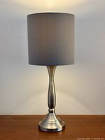 Front view of brushed nickel lamp with grey drum shade