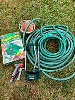 Overview of lot showing FlexiHose box, green hose, sprinkler, nozzle and pots