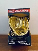 Front view of miniature gold glove trophy in display box