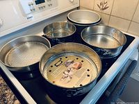 All six pans on stovetop showing variety of springform and cake pans