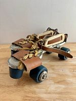 Top view of both skates showing leather straps, laces and blue wheels