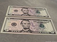 Front of two sequential $5 bills showing serial numbers and Abraham Lincoln