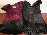 Both velvet dresses laid flat showing textures and internal label