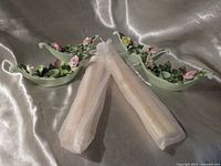 Two bone china candle holders and two organza bags containing beeswax tapers