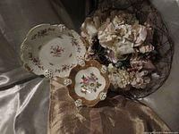 Front view of both Rosenthal porcelain pieces showing floral decoration and pierced rim