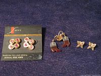 All three pairs of earrings displayed: Savvy crystal studs on card, cowboy boot dangles, butterfly studs