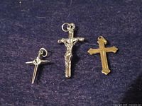 Three cross pendants on blue fabric