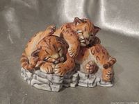Front view of Lenox cougar cubs figurine showing sleeping poses and rock base
