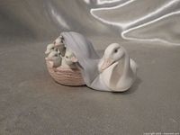 Front view of Lladro porcelain figurine showing mother duck and basket with four ducklings