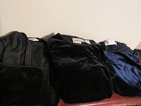 Three folded velvet dresses with visible tags