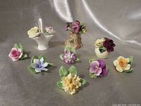 Group of nine floral bone china miniatures displayed
