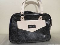 Front view of black Mary Kay tote bag with ivory handles and pocket