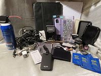 Group shot showing power banks, portfolio, cords, phone cases, stamps, watch cases, cleaning items