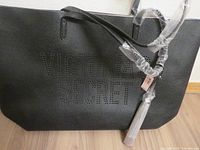 Front view showing perforated Victoria's Secret logo and tassel