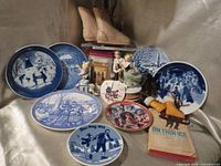 Group shot showing all plates, music box, skates, figurine, book and sand dollar