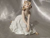 Front view of porcelain ballerina figurine kneeling in matte white dress