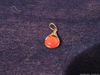 Front view of red cat's eye pendant showing gold plated bezel and bail