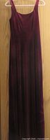 Front view of burgundy velvet full-length sleeveless dress on hanger