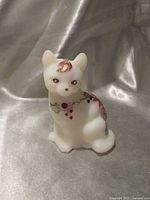 Front view of satin glass cat figurine with poinsettia decoration