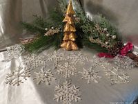 Full lot overview showing snowflake ornaments, gold wooden tree, garlands and pine picks