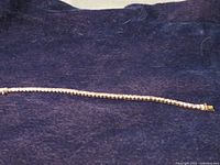 Full view of bracelet on dark background showing length and stone arrangement