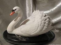 Front quarter view of white porcelain swan on black base