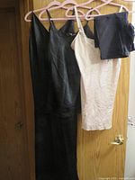 All four garments hanging: long black slip, short black slip, ivory slip, dark shaper
