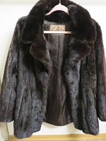 Front view of black mink jacket open to show lining and label