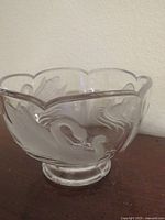 Front view of crystal bowl showing frosted swans and scalloped rim