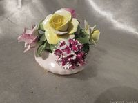 Front view of Radnor floral bouquet figurine showing yellow and pink roses, carnation, footed base