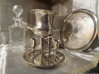 Group view of champagne bucket, crystal decanter, two trays and four goblets