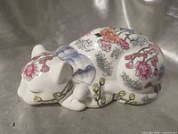 Right side view of porcelain sleeping cat showing floral design