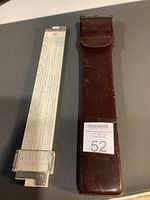 Slide rule alongside leather case