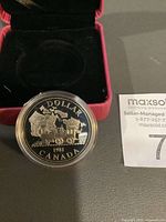 Reverse of 1981 Canada $1 coin in capsule with presentation case