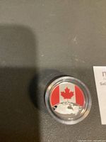 Reverse side showing colorized Canadian flag and globe in capsule