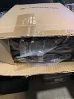Box partially opened revealing sleeping bag inside plastic