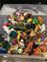 Bin filled with assorted small plastic toy figures