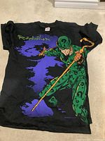 Full view of front of black Riddler graphic T-shirt laid flat