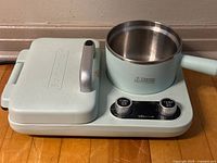 Closed breakfast station showing mint green exterior and stainless pot fitted